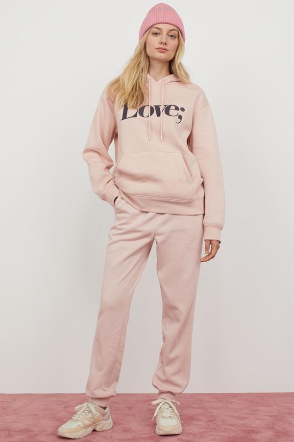 Chándal en color rosa claro con pantalón con puño (19,99 euros) y sudadera con capucha y la palabra 'Love' (14,99 euros), de H&M.