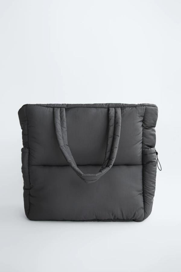 En color gris, este maxi bolso formato shopper con cuerpo acolchado y bolsillos en los laterales cuenta con cierre con cremallera y tiene un precio de 29,95 euros.