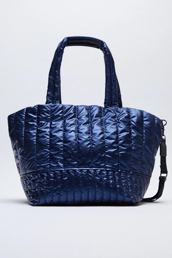 En color azul, este bolso formato shopper está disponible en otros colores. Con cuerpo acolchado de nylon, cuenta con asas de hombro y función bandolera ajustable y extraíble. Tiene un precio de 39,95 euros.