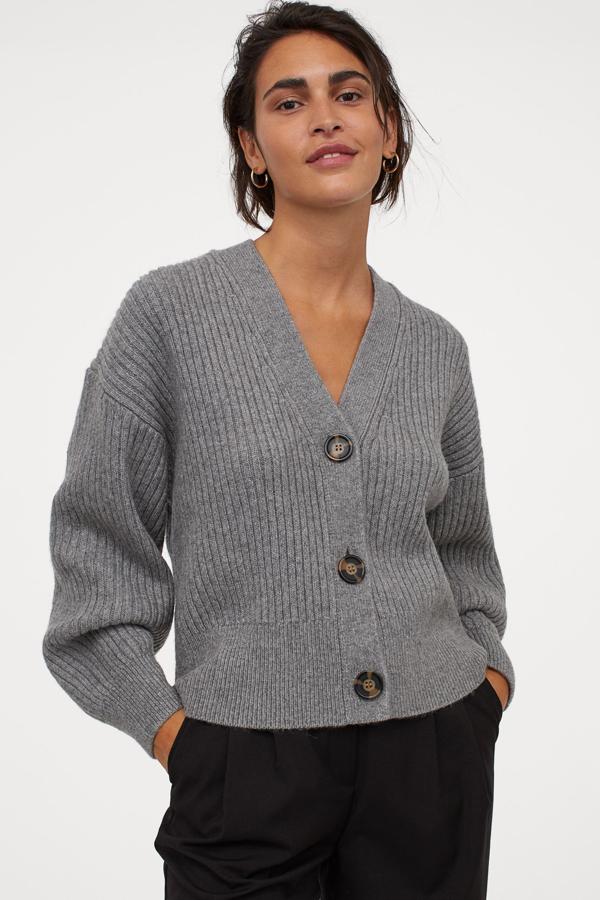 Este cárdigan boxy en punto de canalé de color gris jaspeado cuenta con escote de pico, cierre de botones y remate de canalé en puños y bajo. Tiene un precio de 29,99 euros.