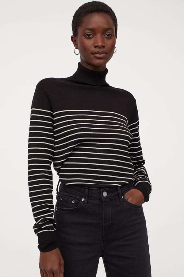 Disponible en varios colores, este jersey en punto fino suave en negro con rayas blancas cuenta con cuello alto de canalé y puños y bajo elásticos. Tiene un precio de 14,99 euros.