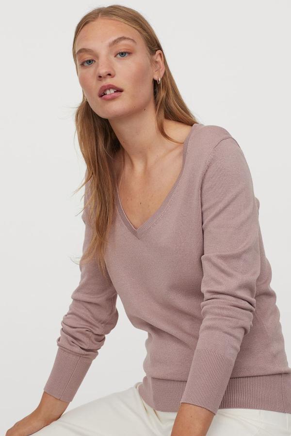 En punto fino de mezcla suave de viscosa con escote de pico pronunciado, este jersey en rosa pálido, negro o gris claro jaspeado tiene remates en canalé en cuello, puños y bajo. Con un precio de 12,99 euros, está disponible entre las tallas XS y XXL.