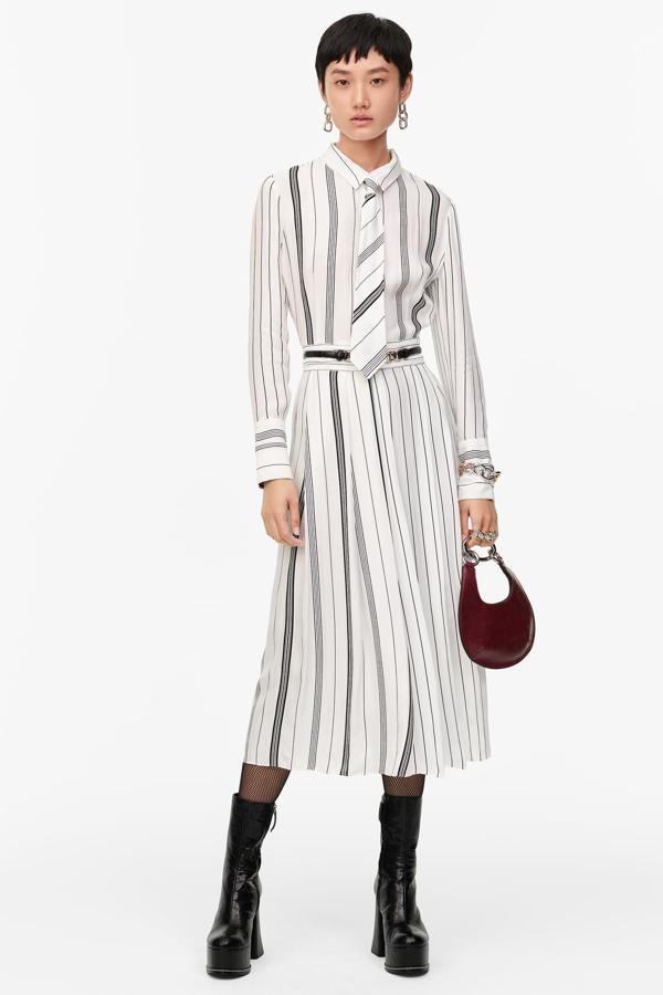 Con la estética de las sufragistas de principios del siglo XX como inspiración, este vestido estampado de rayas con cuello camisero, manga larga y falda tableada (89,95 €) es el aliado perfecto para lucir con una corbata a juego. De Zara.