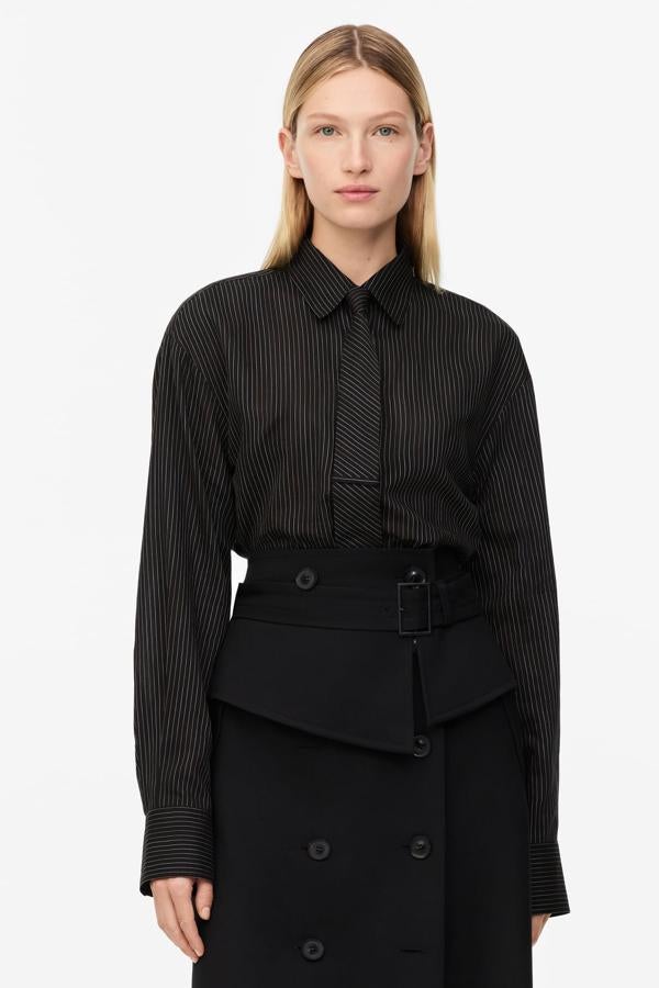 Para los rigores de la oficina, un contraataque de estilo de la mano del clasicismo de una camisa con estampado de raya diplomática y corbata incorporada (49,95 €) y una original falda midi de lana de tiro alto, bolsillos laterales, bajo con pinza en la espalda, cinturón ancho con solapa y hebilla metálica y cierre cruzado frontal con botones (79,95 €), ambas de Zara.