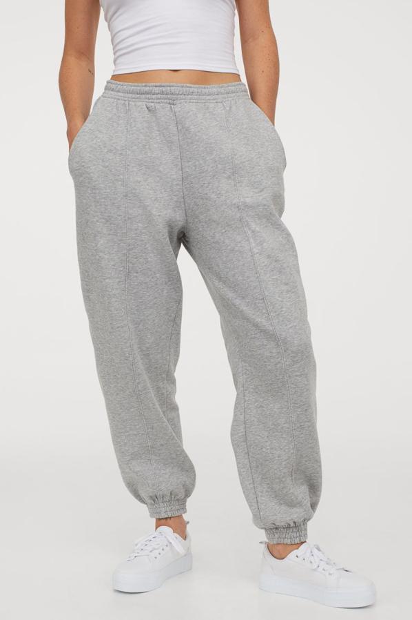 Diseño oversize en tejido sudadera con interior cepillado suave para estos jogger en gris claro jaspeado de H&M con talle alto, cordón de ajuste y bajos elásticos. Confeccionados en poliéster reciclado, cuestan 19,99 euros y están disponibles en las tallas M, L y XL y en negro y blanco.
