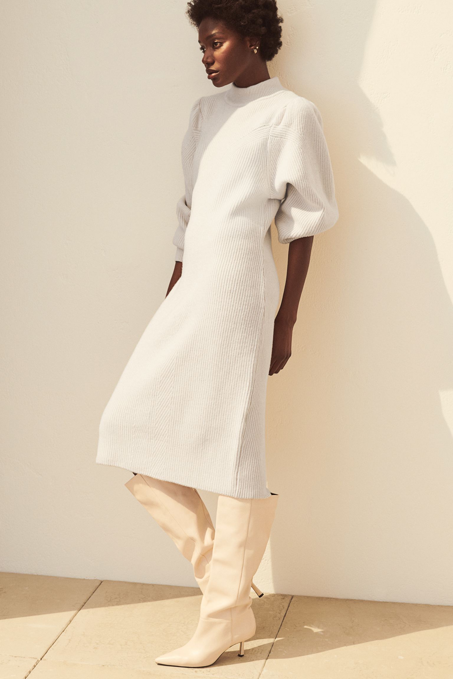 Vestido midi de punto blanco, con manga puffy y cuello Perkins, de H&M (39.99 euros).