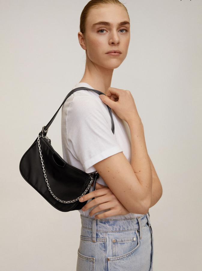 Noventero y hasta nos atrevemos a decir que inspirado en un modelo de Prada. Así es este bolso de Mango con doble asa, larga y corta de cadena (19,99 euros).