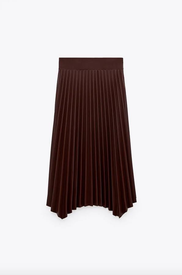 Diseño midi con bajo asimétrico para esta falda plisada en efecto piel de Zara que viene en color burdeos. Tiene el cierre lateral con cremallera oculta en costura y cuesta 29,95 euros. Está disponible entre las tallas XS y XL.