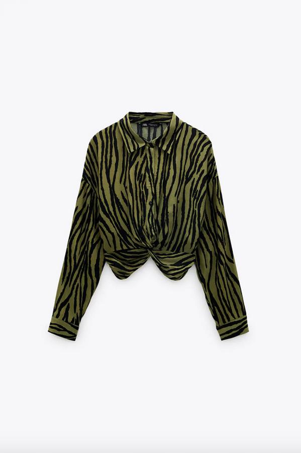 Confeccionada con materiales sostenibles, esta camisa con estampado de cebra en tonos verdes y negros es de Zara y viene con cuello solapa, mangas largas y bajo acabado con nudo. Cuesta 25,95 euros y está disponible entre las tallas S y XL.