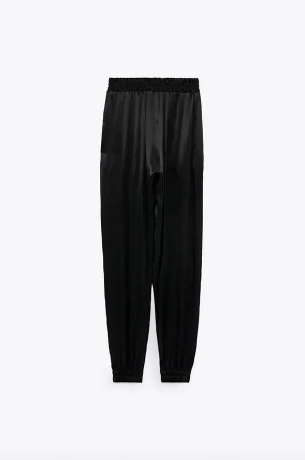 Diseño satinado para este pantalón de Zara con tiro alto y cintura elástica. Con bajo acabado en puño elástico, cuesta 25,95 euros y está disponible entre las tallas XS y XL.