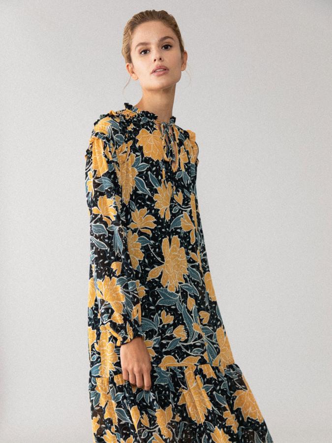 En corte midi y mangas largas con volantes en los hombros, este vestido en tonos mostaza y esmeralda sobre azul marino viene con cuello fruncido con escote en forma de pico y cierre con lazada a tono. Confeccionado en un tejido vaporoso y suave, cuesta 22,99 euros y está disponible en las tallas S, M y L.