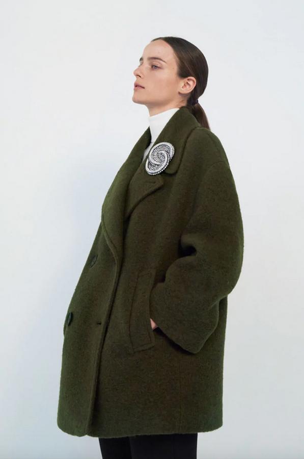 Diseño corto de cuello y solapa con manga larga para este abrigo oversize en caqui de Zara con bolsillos delanteros de vivo y cierre frontal cruzado con botones combinados a contraste. Cuesta 59,95 euros y está disponible entre las tallas XS y XL.