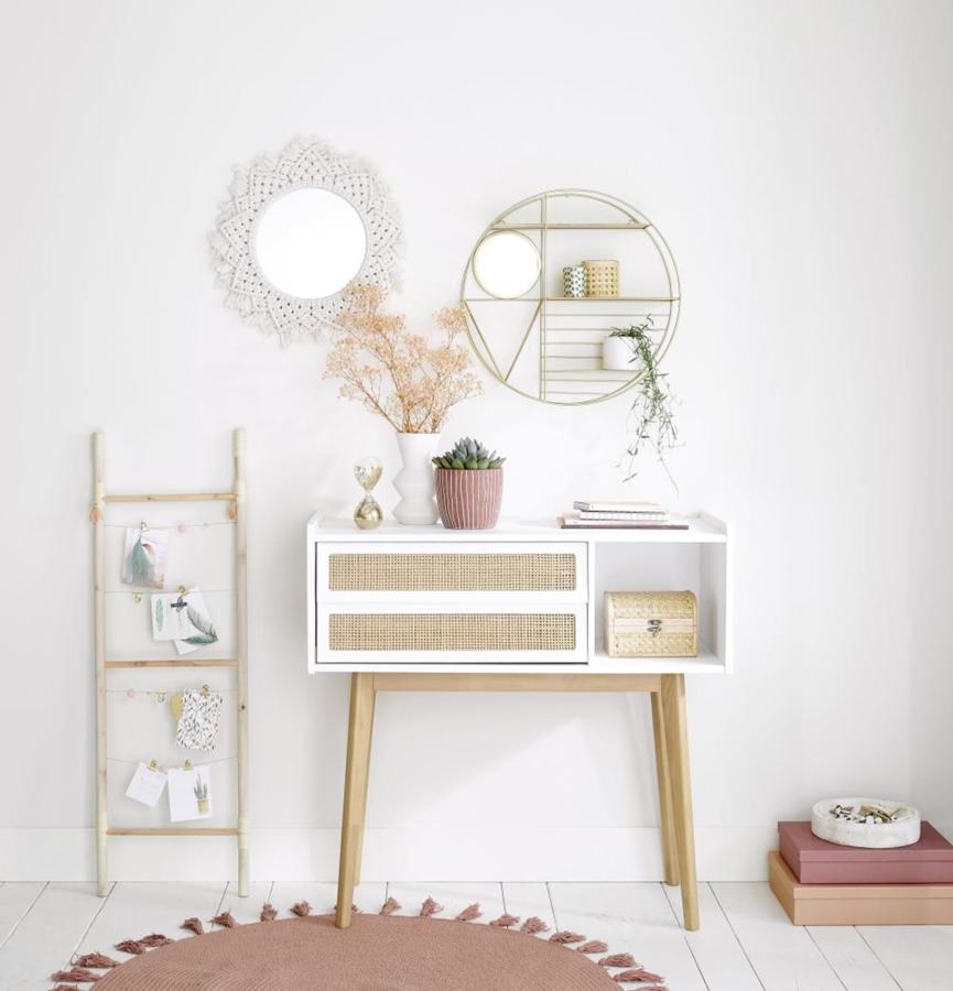 Usar espejos cuyo marco sea del mismo color que las paredes o en la misma gama de color ayuda a que visualmente esas paredes parezcan más amplias. Esta es la propuesta que hace Maisons du monde con este pequeño espejo con marco de macramé trenzado en color marfil (22,99 euros).