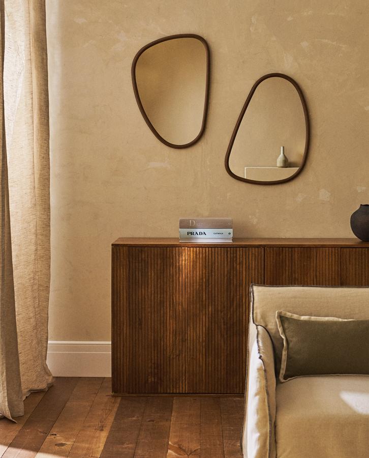 Multiplicarás el efecto óptico de amplitud (y el decorativo) si usas combinaciones de espejos de distintas formas y tamaños. Esta propuesta es de Zara Home y consiste en dos espejos de forma irregular con marco de madera, lo que aporta calidad al conjunto. Cada uno cuesta 39,99 euros.