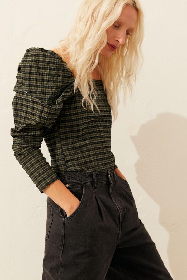 Blusa en tejido arrugado de mezcla de algodón de H&M (19,99 euros). Lleva escote cuadrado delante y detrás y va ligeramente entallada. Las mangas largas, abullonadas, incluyen un elástico en los hombros. Cierra con una cremallera oculta en un lateral.