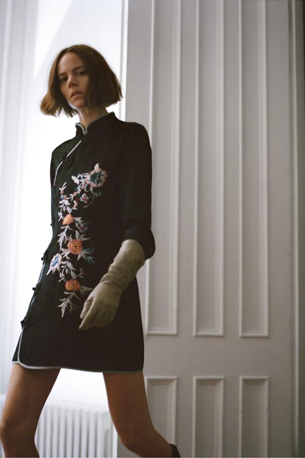 Vestido corto de cuello subido y manga larga con detalle de bordados y cierre frontal con alamares, de Zara (49,95 €).