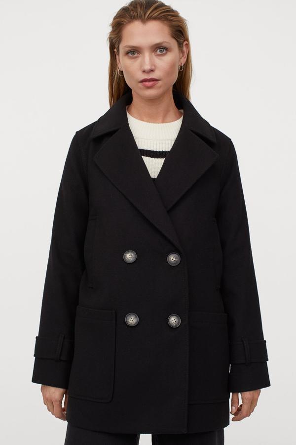 Este abrigo corto de doble botonadura y trabilla en los puños cuenta con bolsillos parche en la parte delantera y abertura en la parte trasera. Es de H&M y tiene un precio de 49,99 euros.