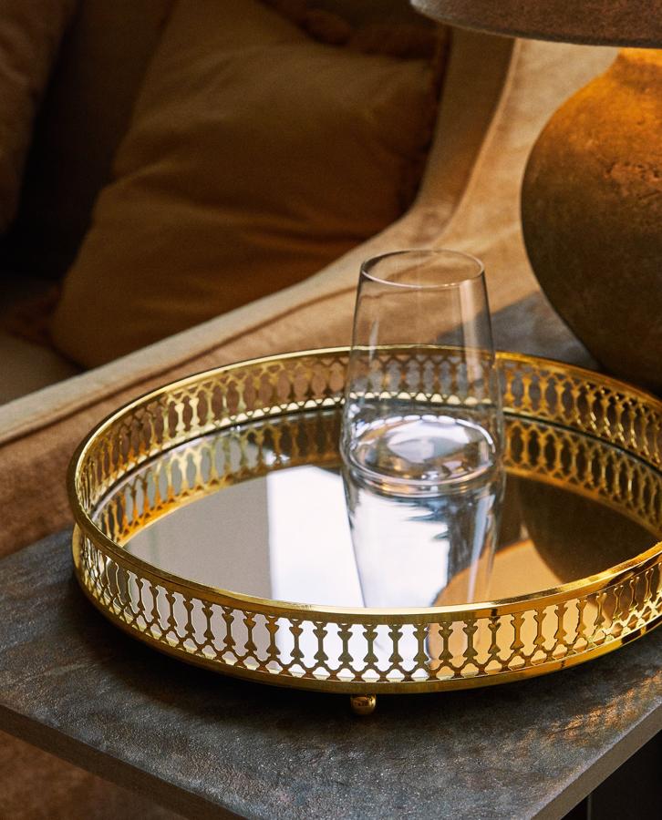 Esta bandeja redonda en metal dorado y espejo tiene 30 centímetros de diámetro y un precio de 29,99 euros.