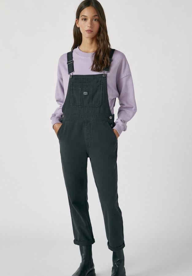 En color negro y con un pequeño detalle de logo, este peto largo con tirantes ajustables y bolsillos está confeccionado en 100% algodón y tiene un precio de 29,99 euros.