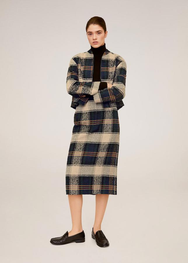 De inspiración vintage con guiños muy british: chaqueta corta y falda tubo por debajo de la rodilla con estampado de cuadros y mocasines de piel negros, todo de Mango.