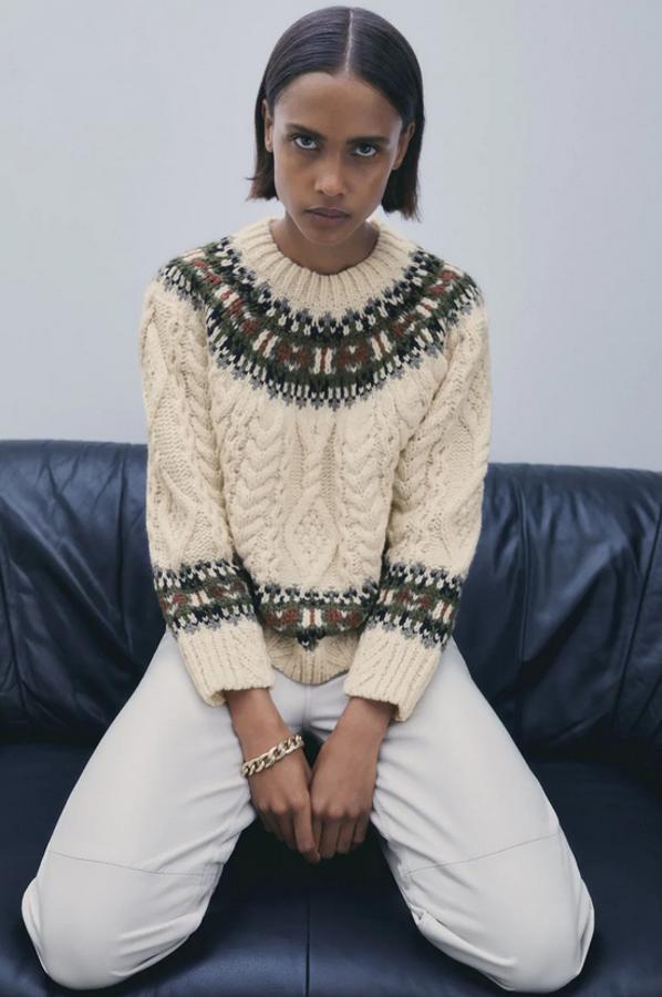 Diseño de ochos con cuello redondo y manga larga para este jersey de Zara con detalle jacquard combinado a contraste en tonos verdes, negros y burdeos. Cuesta 39,95 euros y está disponible en las tallas S y M.