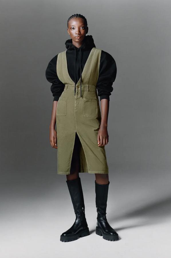 Diseño midi para este pichi en color caqui de Zara con escote de pico y tirantes anchos. Tiene bolsillos de plastrón en los laterales, detalle de abertura delantera en el bajo y cierre frontal con cremallera y botón metálico. Cuesta 29,95 euros y está disponible entre las tallas XS y XL.