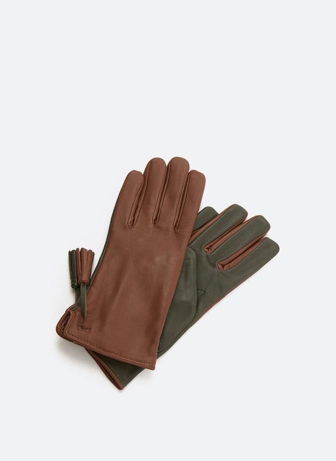 Confeccionados en piel de alta calidad a contraste con detalle de pompón en los laterales externos de las muñecas, estos guantes marrones con dorso negro son de Uterqüe y cuestan 49 euros. Podemos encontrarlos en las tallas S y M.