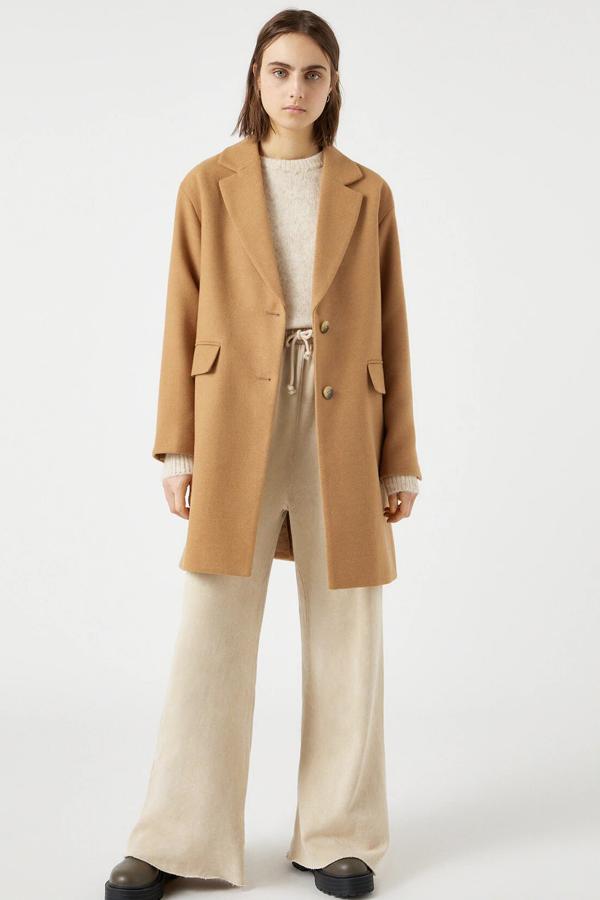 Disponible en camel o negro, este abrigo básico con doble botón es de Pull & Bear y tiene un precio de 39,99 euros.
