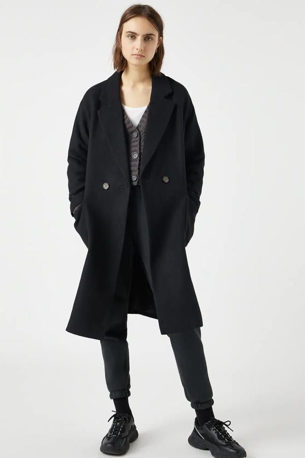 En tejido de paño con bolsillos de plastrón en la parte delantera, este abrigo negro está también disponible en crudo. Es de Pull & Bear y tiene un precio de 49,99 euros.