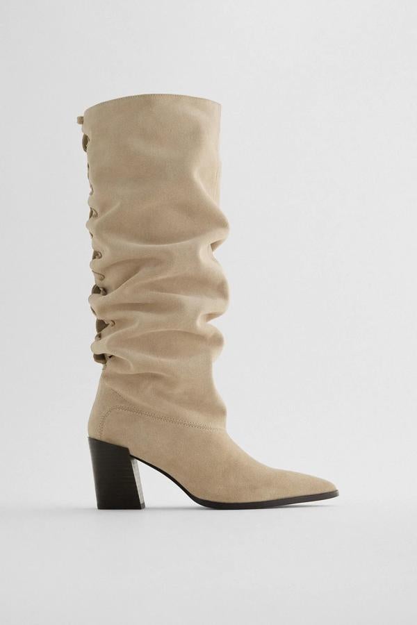 En color beige, esta bota alta con detalle trenzado en la parte trasera cuenta con tacón medio ancho de 7,5 centímetros de altura y tiene un precio de 79,95 euros.