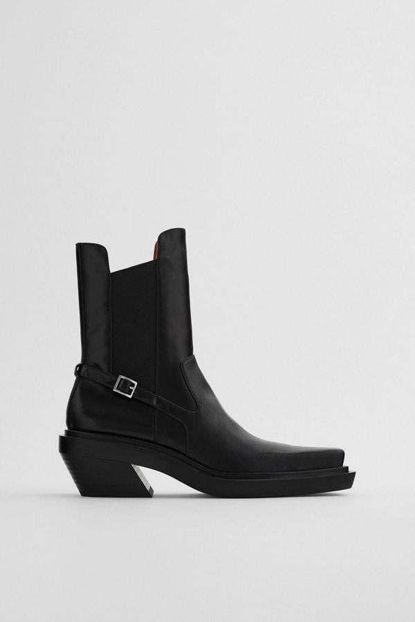 Este botín de piel en color negro y tacón cowboy cuenta con elásticos en los laterales y detalle de hebilla lateral. Acabado en punta cuadrada, tiene un precio de 89,95 euros