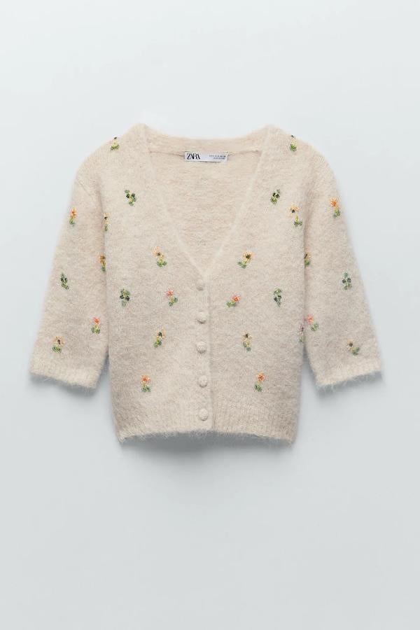Con detalle de abalorios bordados en forma de flor, este cárdigan de punto en color beige y con escote de pico tiene un precio de 39,95 euros. Es de Zara.