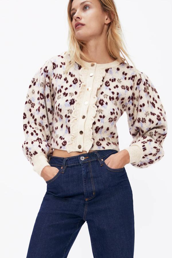 Con detalle de chorreras en la parte delantera y manga larga abullonada, esta chaqueta de punto jacquard en color crudo cuenta con cierre frontal con botones dorados. Es de Zara y tiene un precio de 29,95.