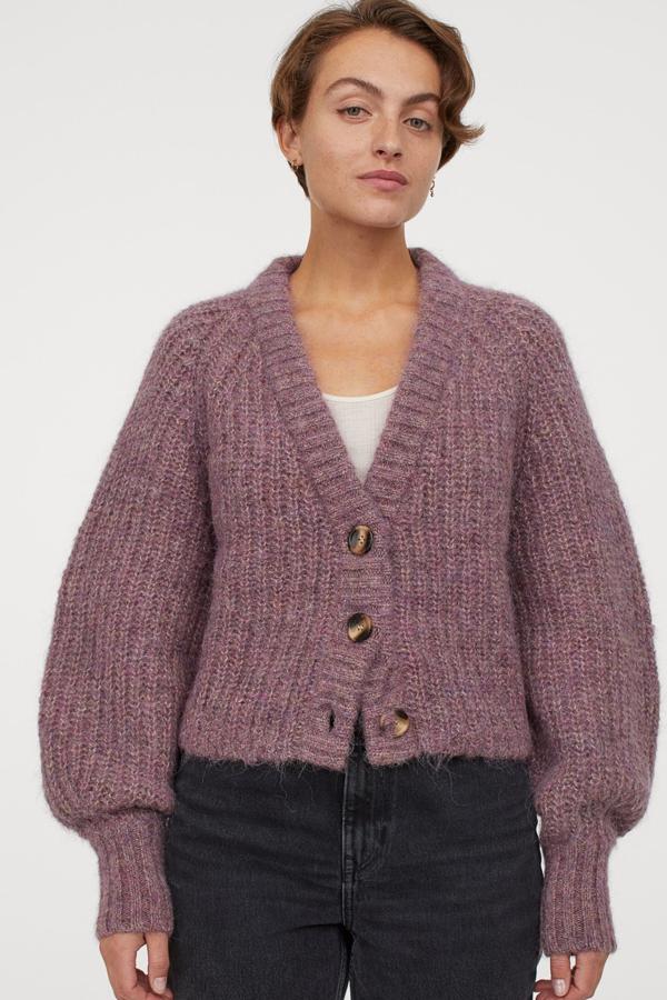 Disponible en lila o mostaza, este cárdigan corto en punto de mezcla de lana y alpaca cuenta con mangas amplias más ceñidas en los puños y tiene un precio de 49,99. Es de H&M.