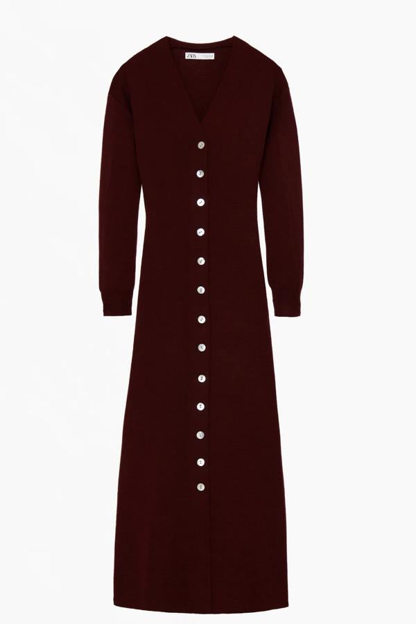 Este vestido midi de punto en color burdeos cuenta con escote de pico y cierre frontal con botones. De manga larga y bajo acabado en evasé, forma parte de la edición limitada de Zara y tiene un precio de 59,95 euros.