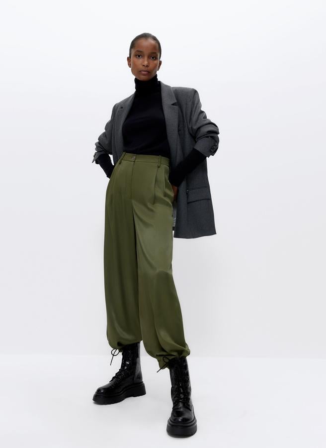 Confeccionado en tejido fluido y satinado, este pantalón caqui viene con pliegues en la cintura, bolsillos laterales y de vivo en la espalda y un diseño amplio apto para todo tipo de looks. De 79 euros ha pasado a 59,25 y está disponible entre las tallas XS y L.