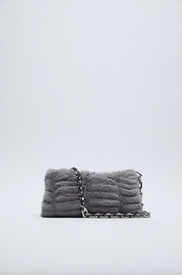 Este bolso de hombro en color gris en efecto pelo en el cuerpo es de Zara y viene con asa de hombro en cadena gruesa y cierre de cremallera. Tiene un precio de 25,95 euros.