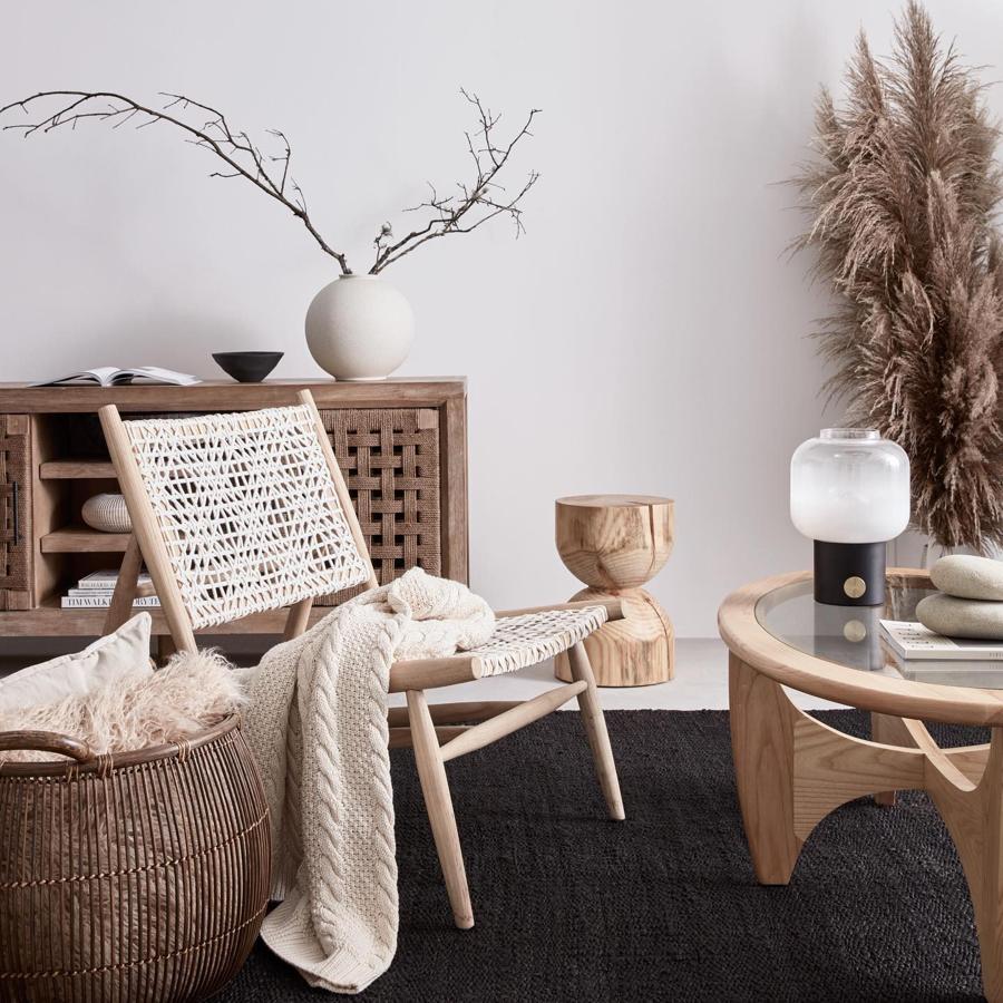 Sofisticación y calidez en este rincón que nos proponen desde Amazon Home. El sillón de fibras naturales y madera cuesta 240 euros y el cojín de plumas, 10.99 euros.