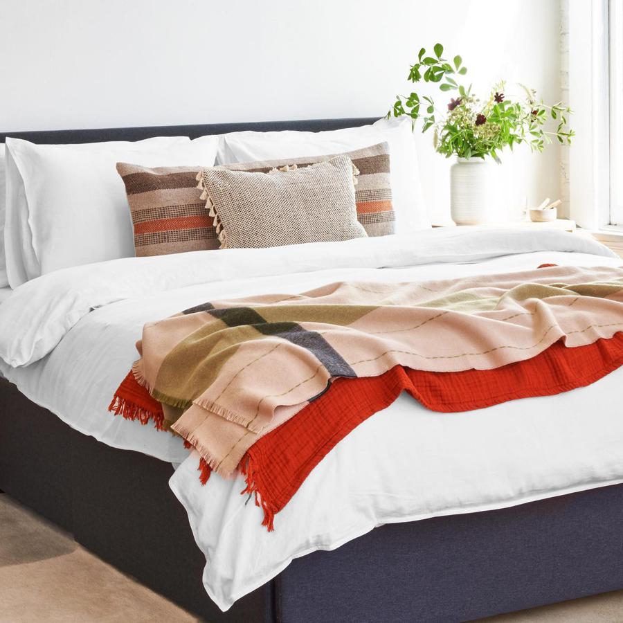 Una habitación cálida con toques de color gracias a textiles como la colcha roja (28 euros) o los cojines (a partir de 40 euros).