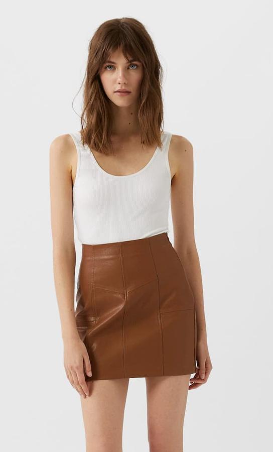Esta minifalda de efecto piel en color camel cuenta con detalles de costuras y cierre mediante cremallera. Es de Stradivarius y tiene un precio de 17,99 euros.