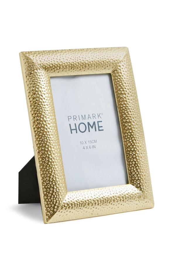 Este marco de fotos dorado con decoración repujada sirve para fotografías de 10x15 centímetros y tiene un precio de 4 euros.