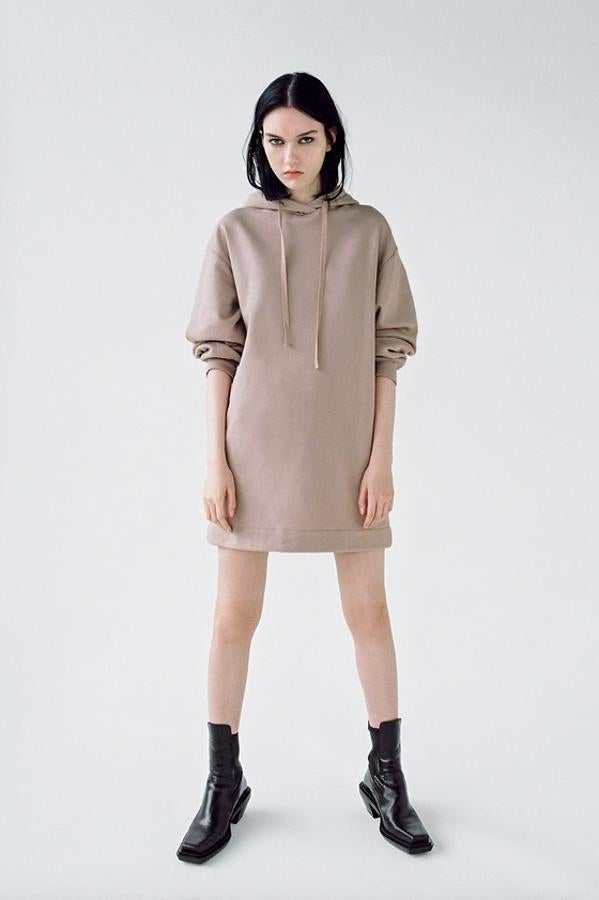 Confeccionado en felpa y con manga larga acabada en elástico, este vestido de Zara con capucha está disponible en gris, beige y negro. Pertenece a la colección sostenible de la firma y podemos encontrarlo en las tallas S, M y L por 17,95 euros.