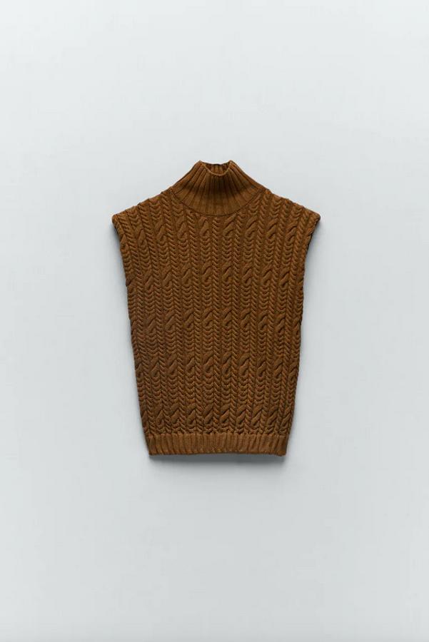 El tradicional diseño de ochos llega a este bonito chaleco de punto de Zara con cuello subido y manga sisa. Podemos encontrarlo entre las tallas S y XL por 22,95 euros.