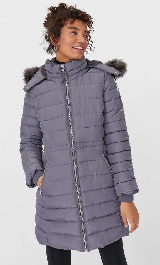 Stradivarius nos propone este abrigo en color gris (también disponible en negro), que cuenta con capucha con aplicación efecto piel y tiene un precio rebajado de 55,99 euros.