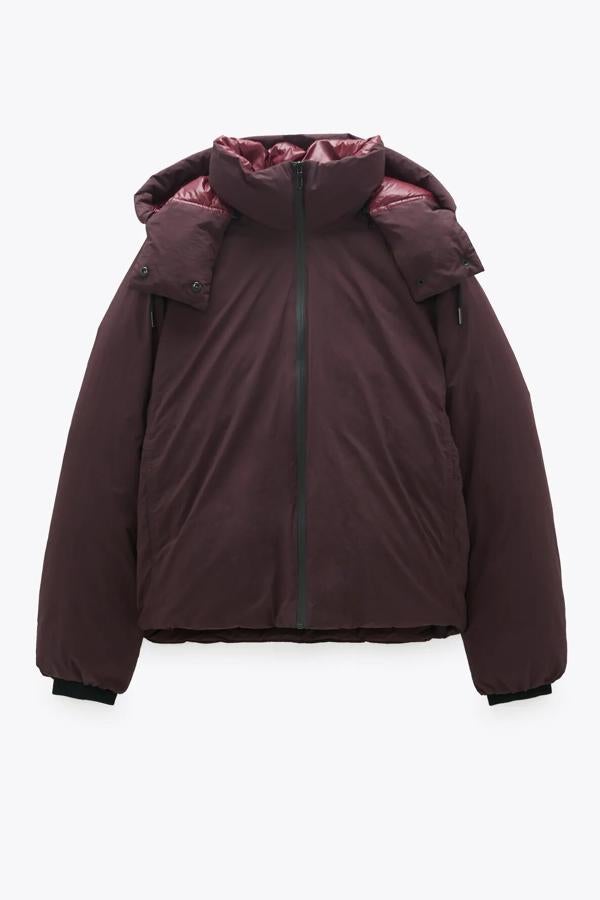 En color burgundy, este plumífero de edición limitada de Zara tiene relleno de pluma y plumón. Con capucha desmontable con cremallera, cuenta con bolsillos laterales y bajo ajustable con cordones elásticos y tiene un precio de 59,95 euros.