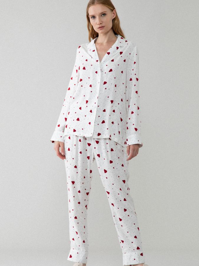 En color blanco roto con estampado de corazones rojos cuenta con pantalón largo ajustable con goma y cordones y parte de arriba con botones. Tiene un precio de 12,99 euros.