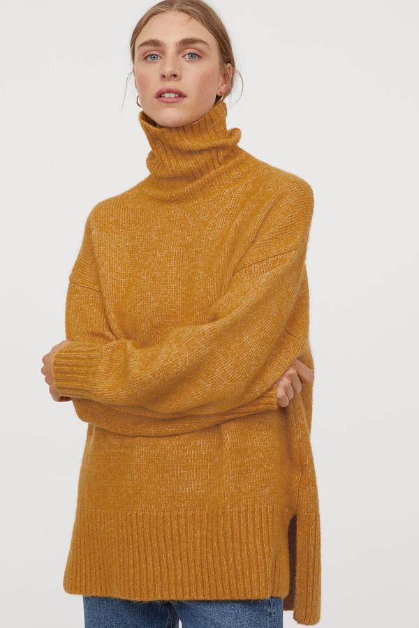 Este jersey oversize en punto suave de color amarillo cuenta con ribete de canalé en puños y bajo y aberturas laterales. Confeccionado con poliéster reciclado, es de H&M y tiene un precio de 29,99 euros.