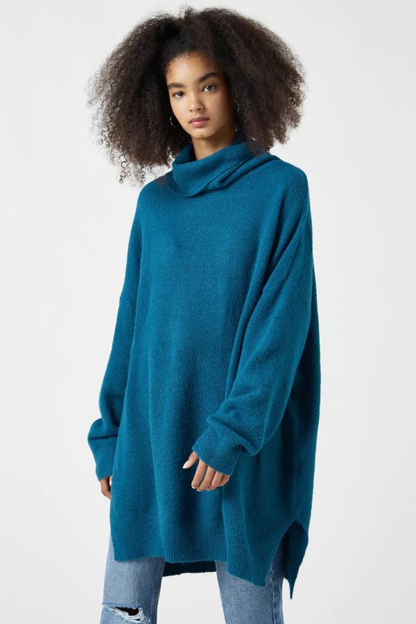 Disponible en verde azulado o en rosa, este jersey oversize de punto con cuello alto y aberturas en el bajo es de Pull & Bear y tiene un precio de 25,99 euros.