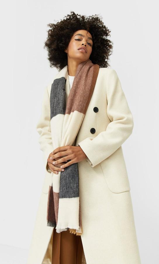 Diseños estructurado de cuadros en negro, marrón y blanco para esta bufanda de Stradivarius de acabado desflecado que cuesta 12,99 euros.