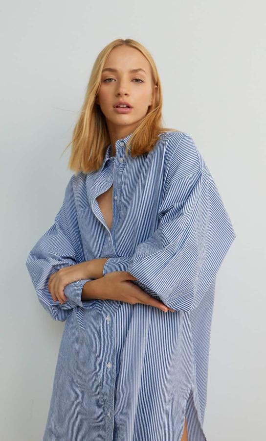Diseño amplio con cuello de solapa y manga larga para esta camisa de rayas blancas y azules de Stradivarius con cierre frontal de botones. Cuesta 19,99 euros y está disponible entre las tallas XS y L.